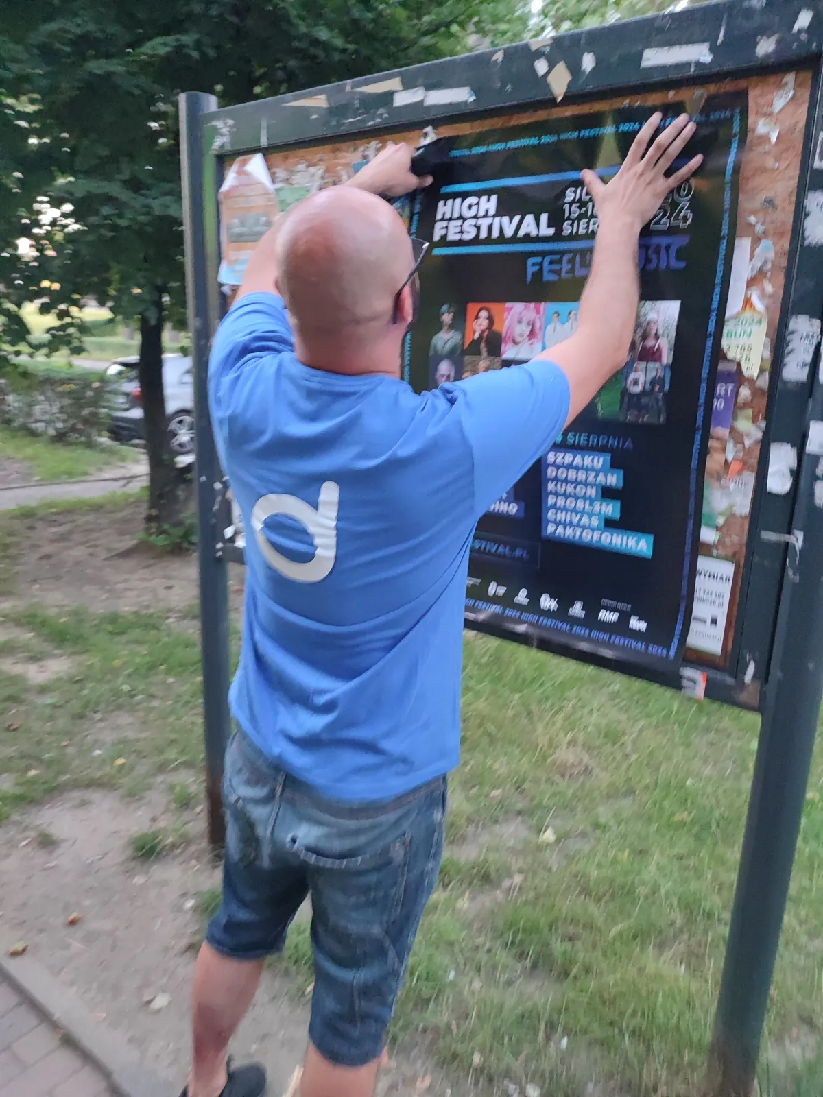 Naklejanie plakatu na tablicy ogłoszeń