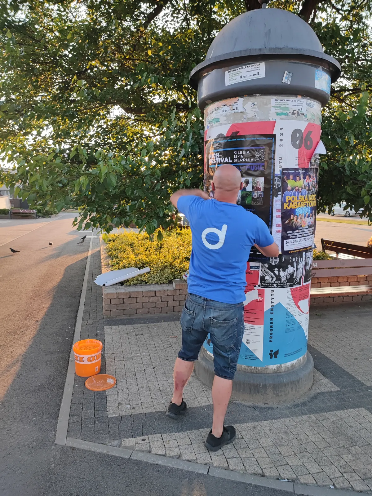 Rozwieszanie plakatów na słupie ogłoszeniowym