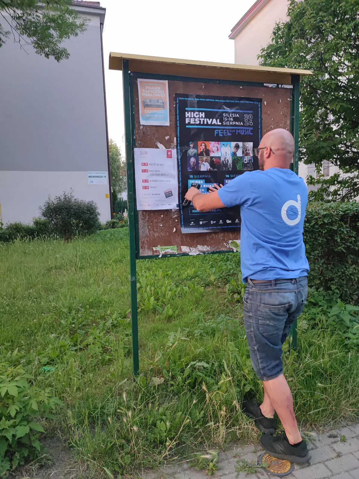 Tablica ogłoszeń na osiedlu z naklejanym plakatem